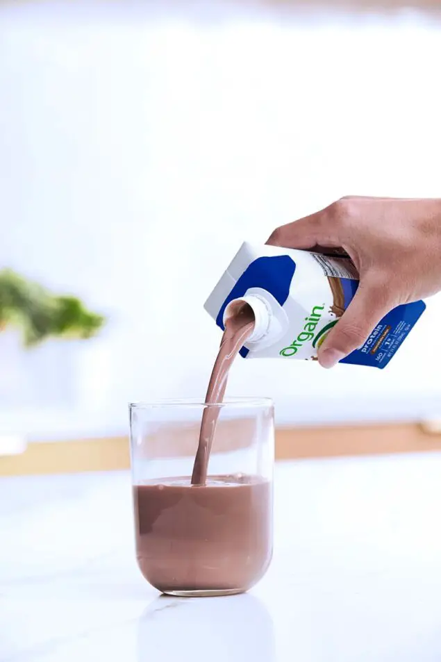 Orgain 30g Protein Ready-to-drink Chocolate pouring into glass on counter